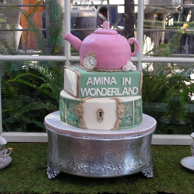 Alice in Wonderland birthday cake with a pink teapot topper and playing-card details Alice in Wonderland birthday cake with a pink teapot topper and playing-card details