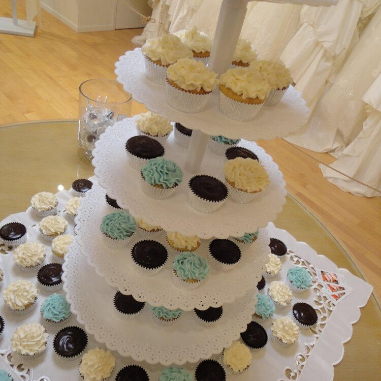Tiered cupcake stand of white-frosted cupcakes topped with chocolate cookie pieces Tiered cupcake stand of white-frosted cupcakes topped with chocolate cookie pieces